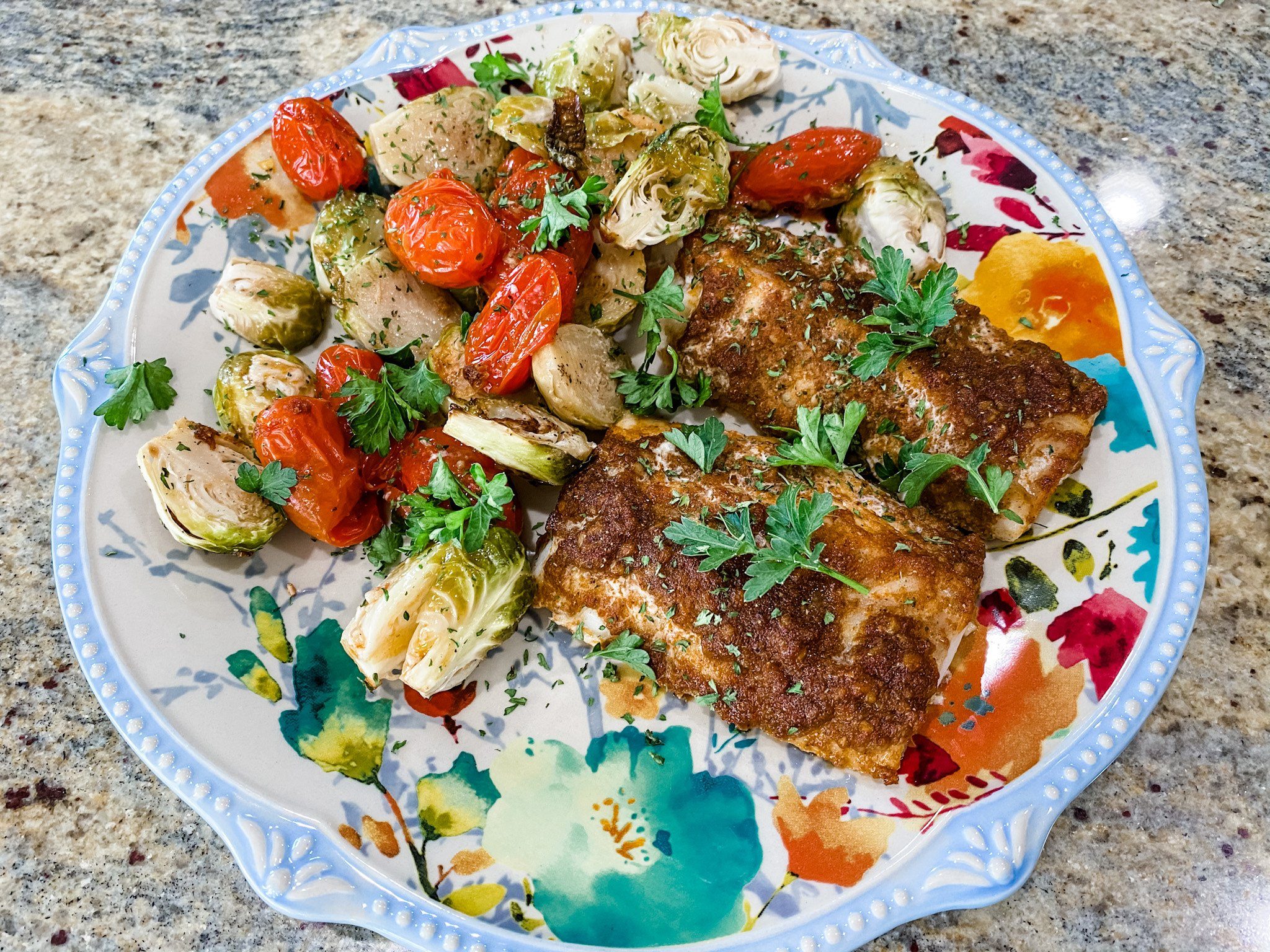 roasted cod with brussels sprouts and cherry tomatoes served on a plate