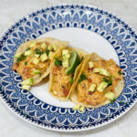 Tacos filled with creamy queso chicken and toppings