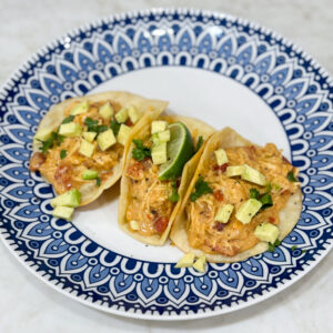 Tacos filled with creamy queso chicken and toppings