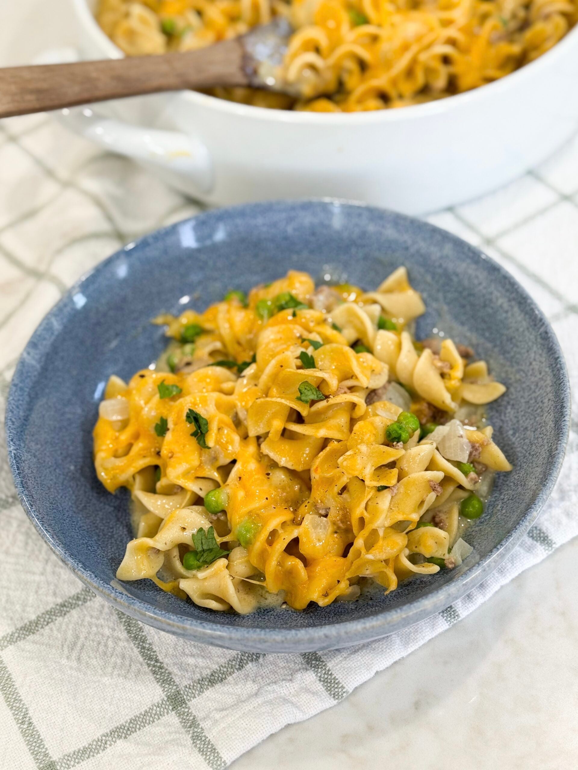 Ground beef stroganoff casserole in a baking dish topped with melted cheese