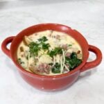 Bowl of zuppa toscana soup topped with Parmesan