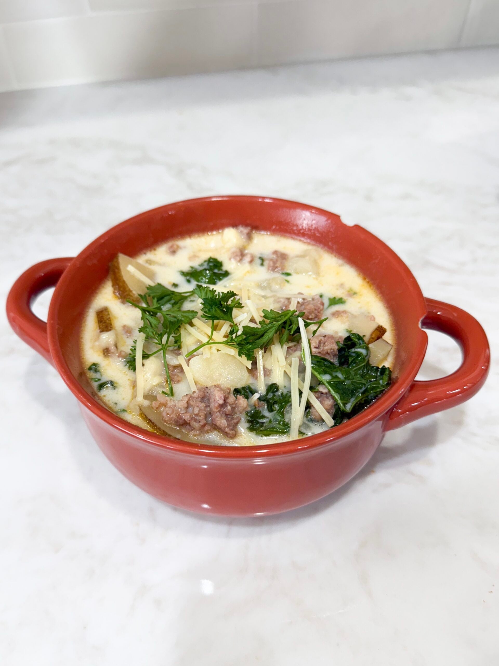 Bowl of creamy zuppa toscana soup with sausage, potatoes, and kale