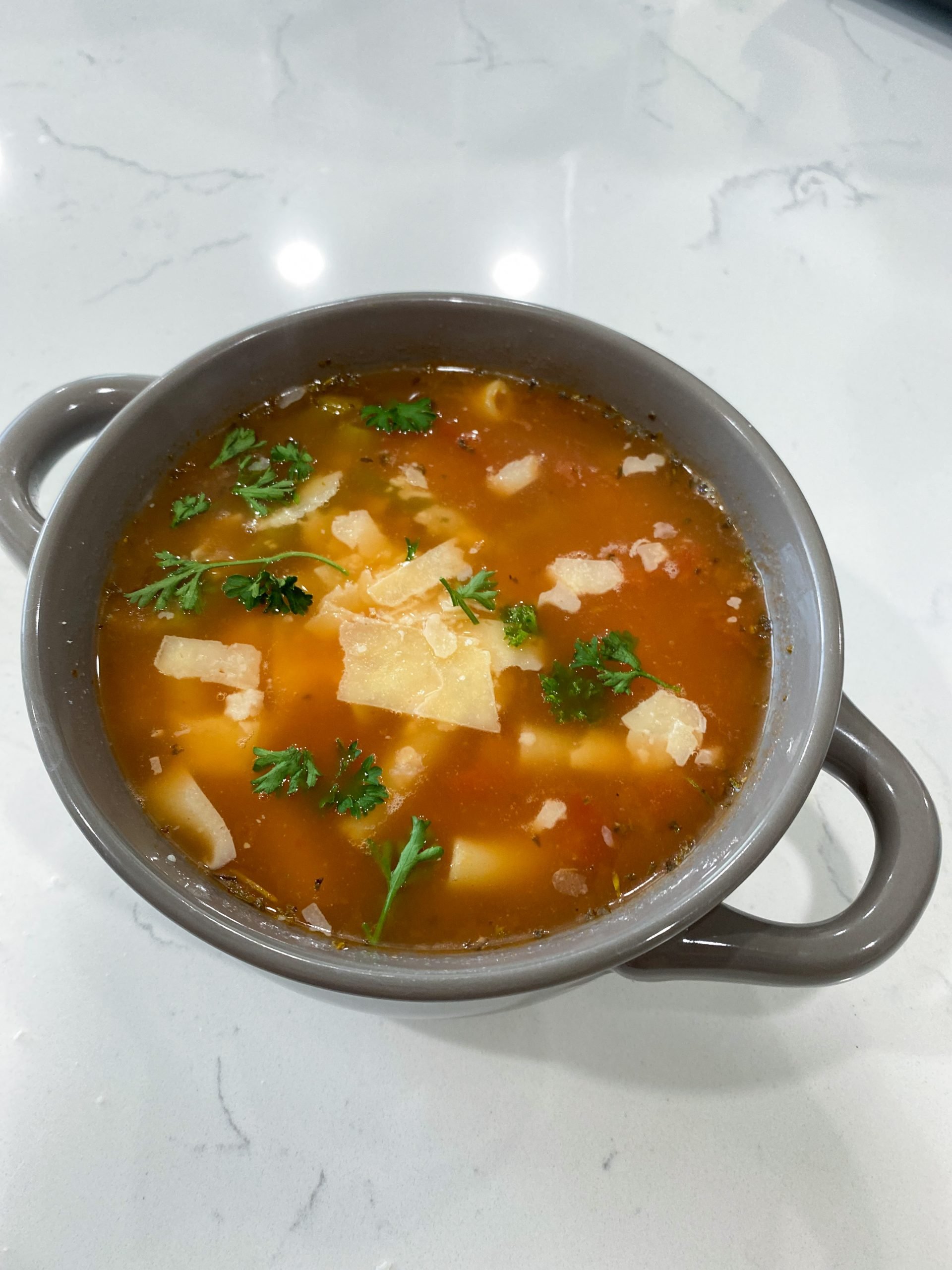Bowl of vegetable noodle soup with noodles, beans, and green beans in tomato broth