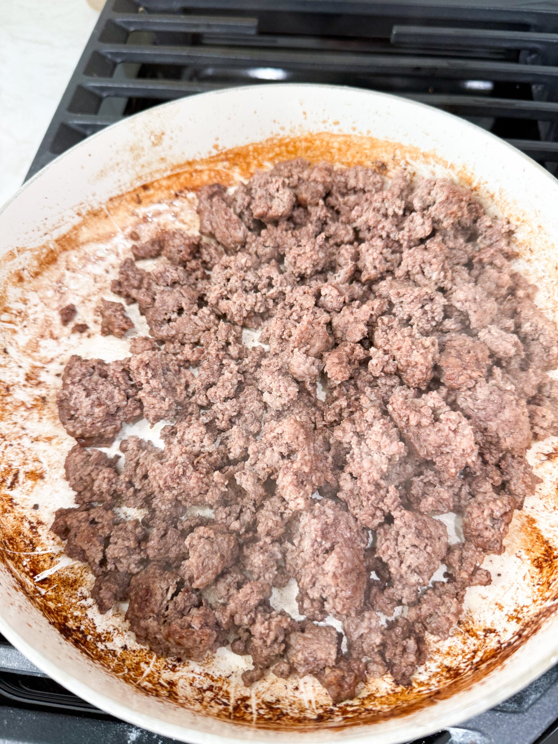 ground beef cooking in a large pan on the stove