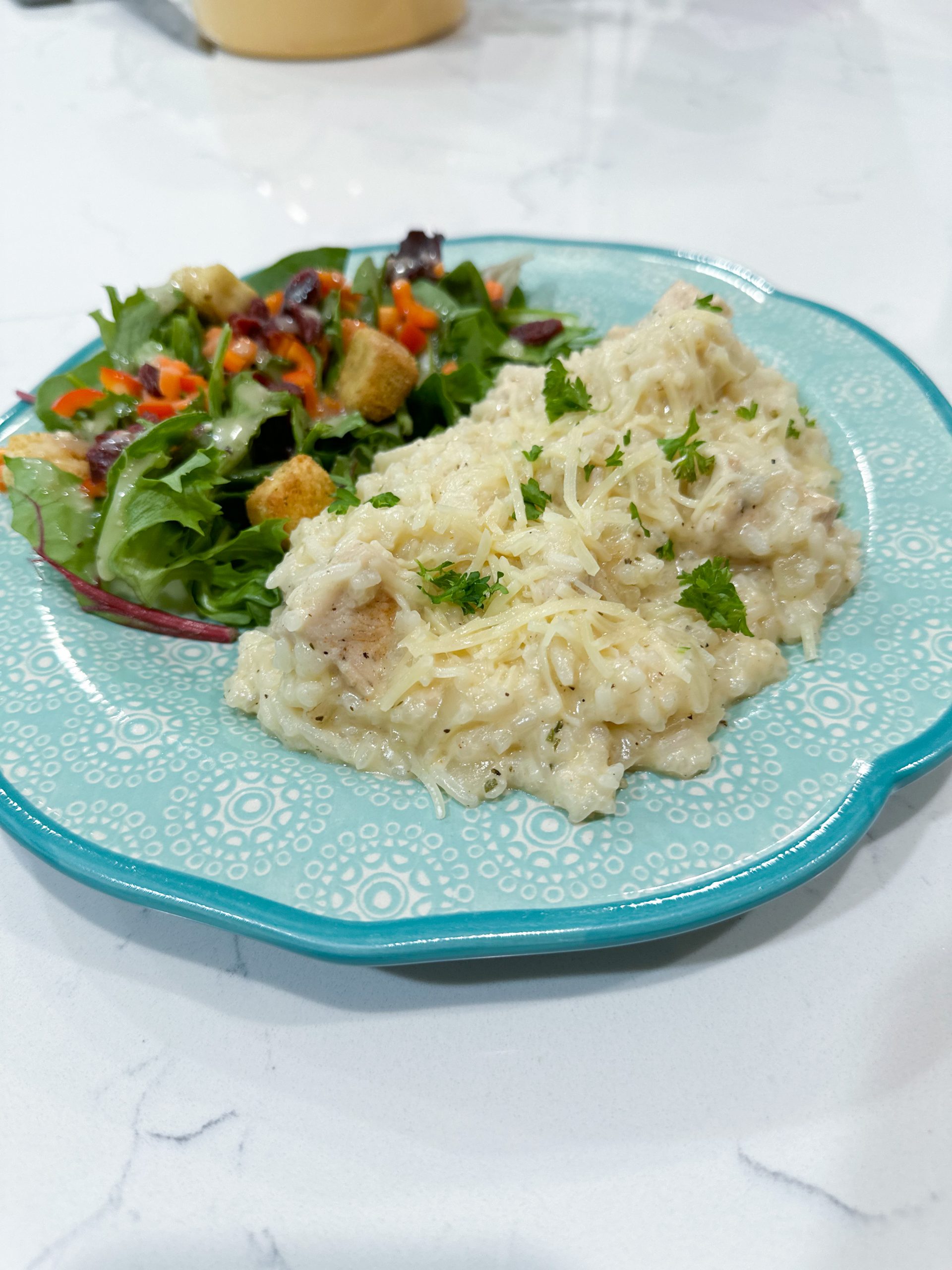 creamy Italian chicken and rice on a plate served with a green salad