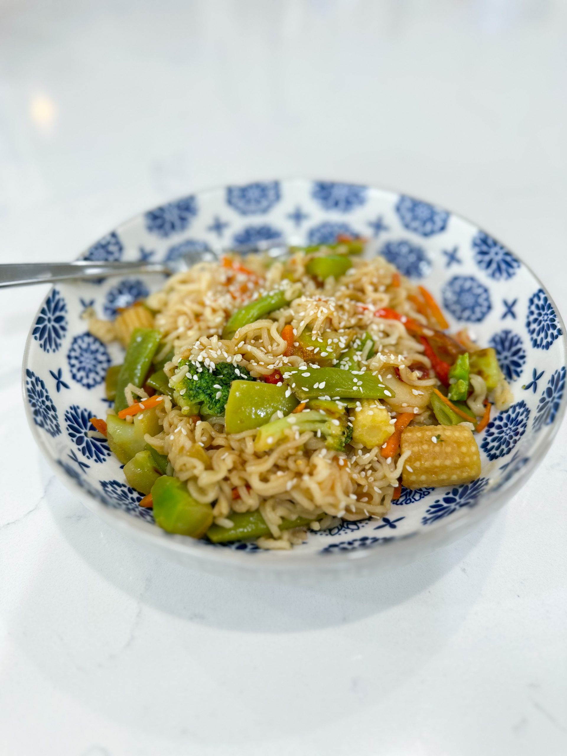 Bowl of ramen noodle stir fry with colorful vegetables