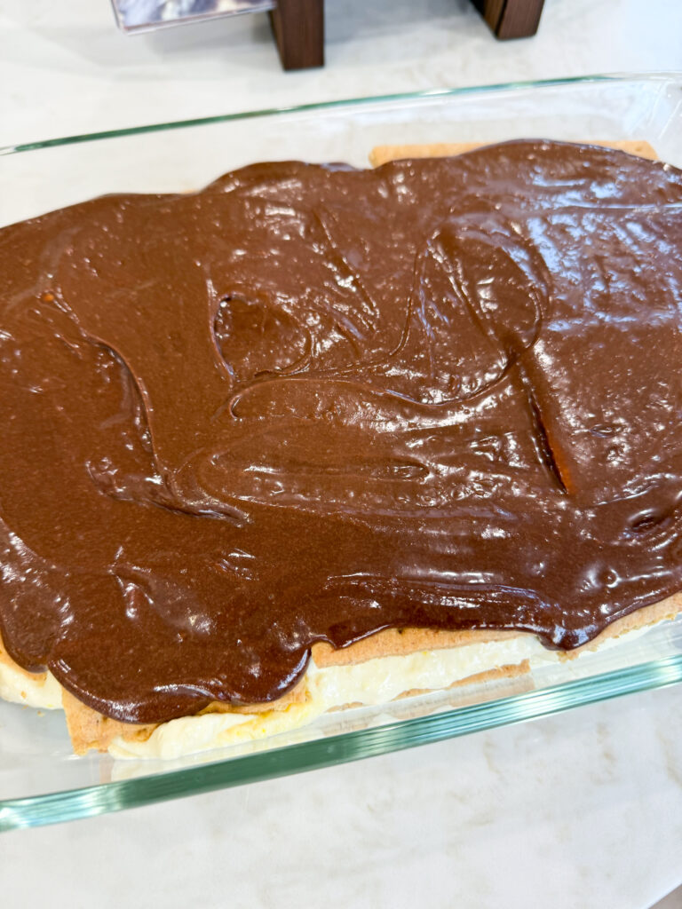 Layered eclair no-bake cake topped with chocolate frosting