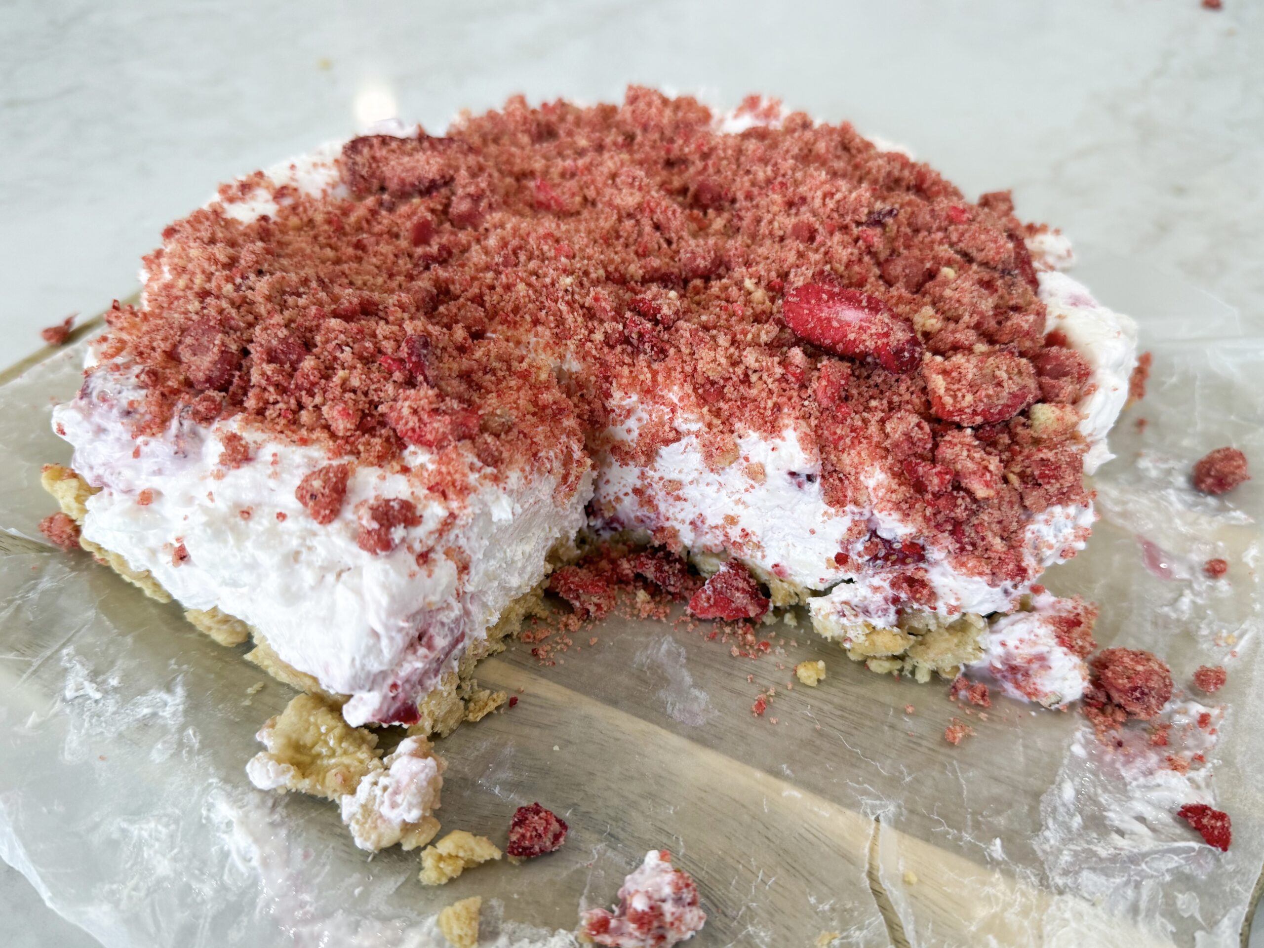 No-bake strawberry crunch cheesecake topped with golden Oreo strawberry crumble