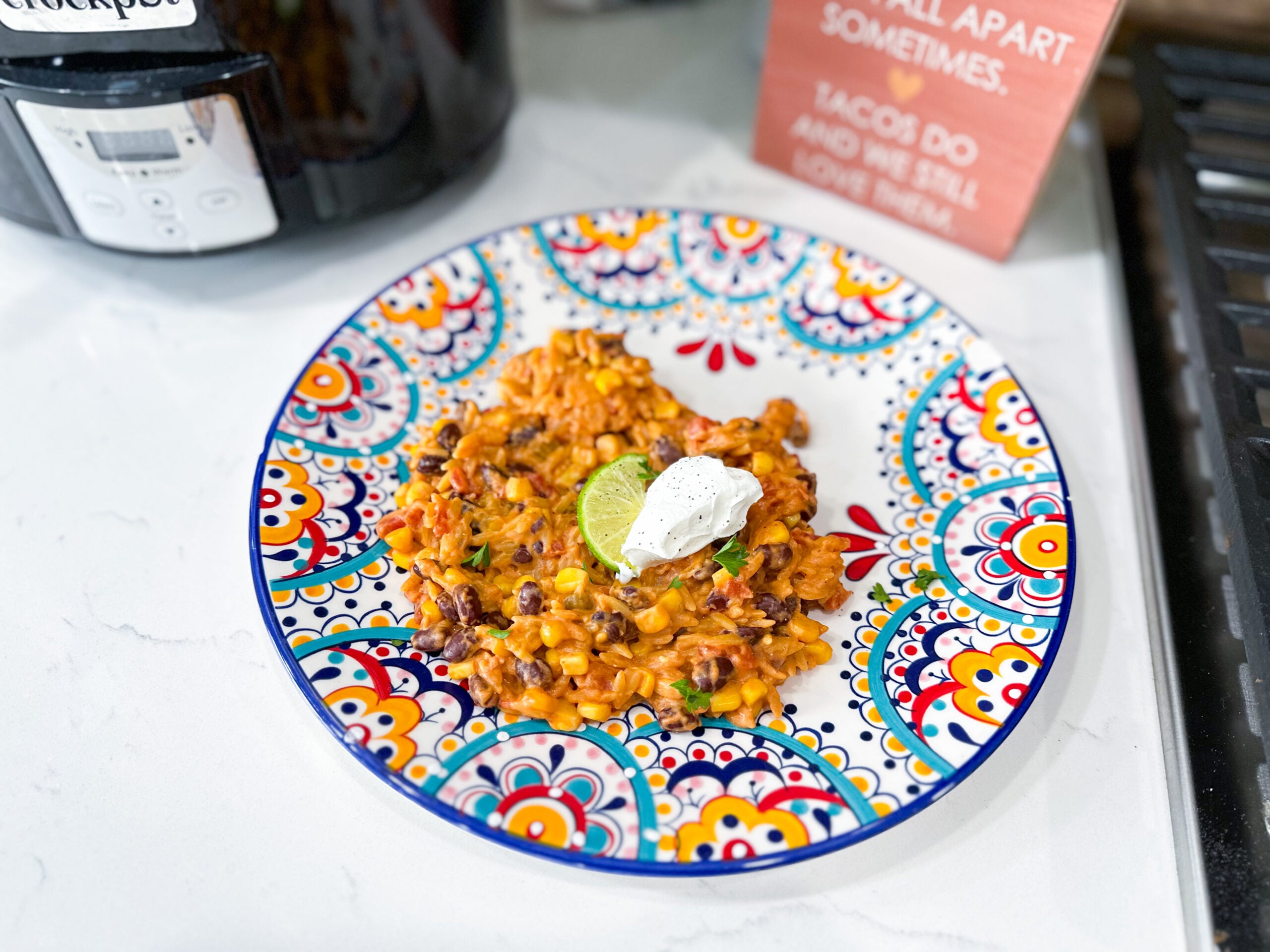 slow cooker Mexican orzo casserole with black beans, corn, tomatoes, and cheese on a plate
