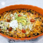 Fiesta chicken casserole baked with melted cheese and colorful toppings
