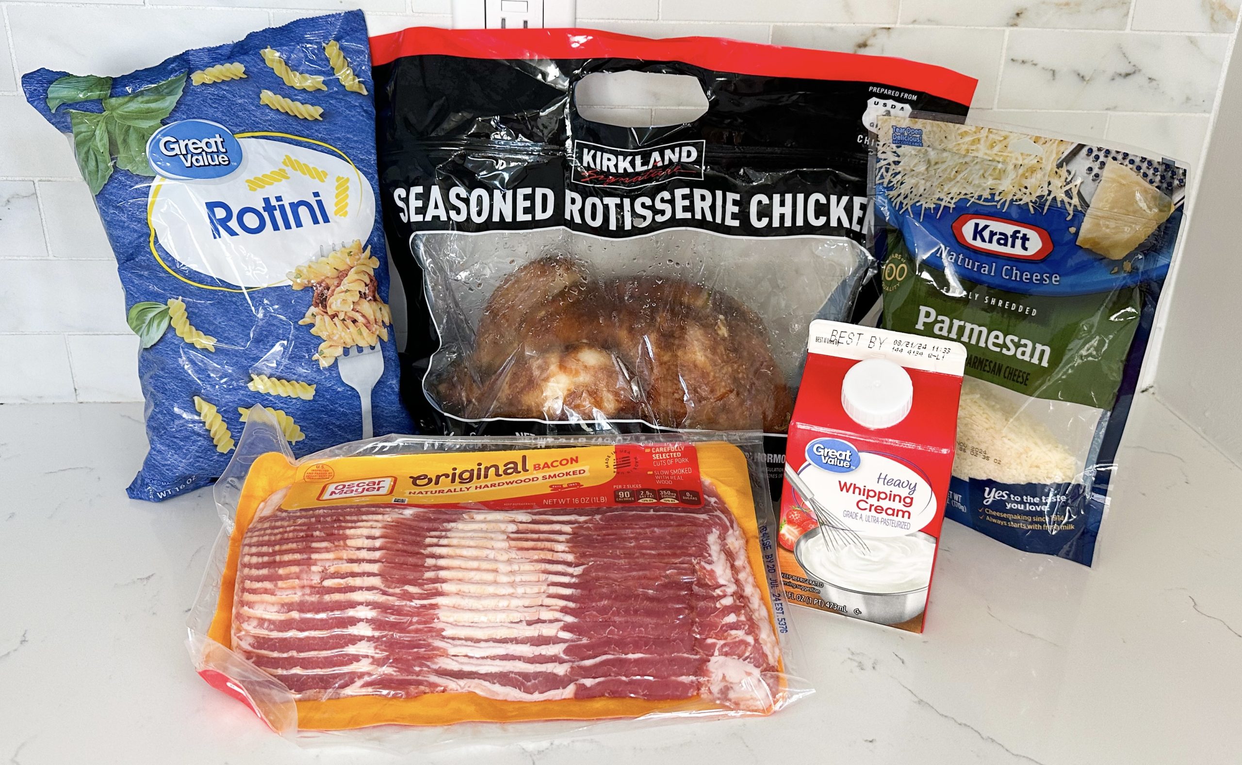 pasta, bacon, rotisserie chicken, cream, and Parmesan on counter
