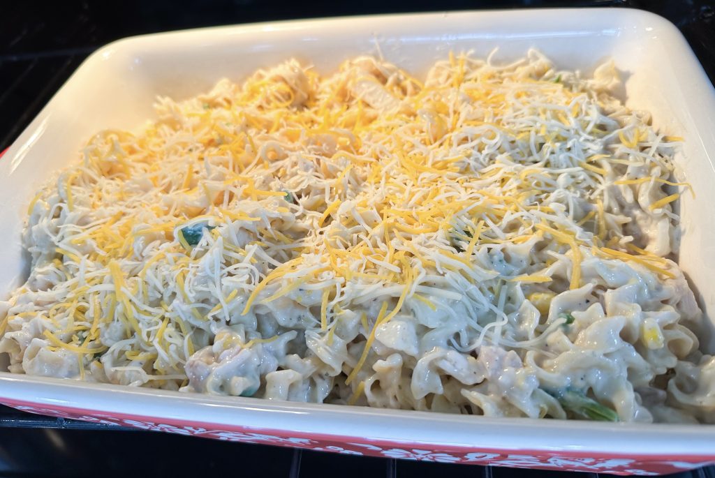 Chicken Noodle Casserole in baking dish topped with cheese.
