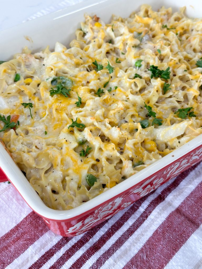 Baked chicken noodle casserole in dish with golden cheese topping