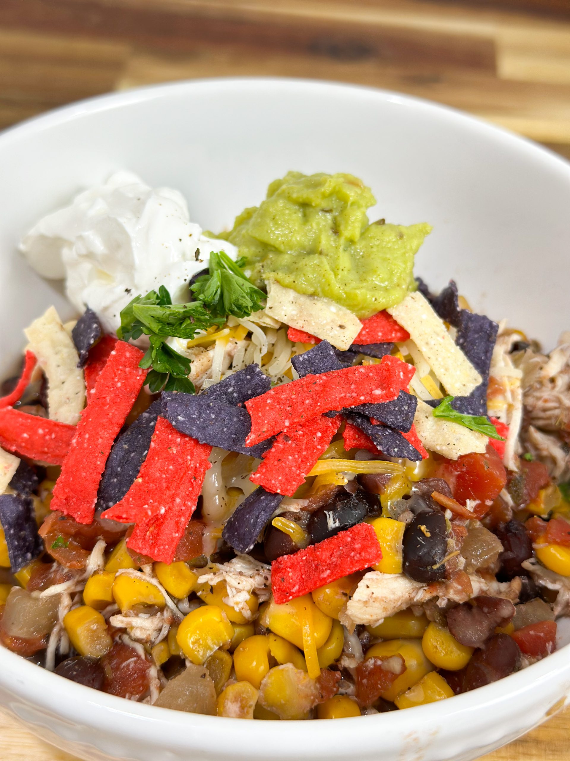 Easy slow cooker chicken burrito bowl with toppings on a plate.
