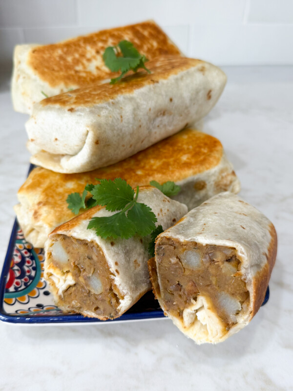 Lentil burritos stacked up on a plate.