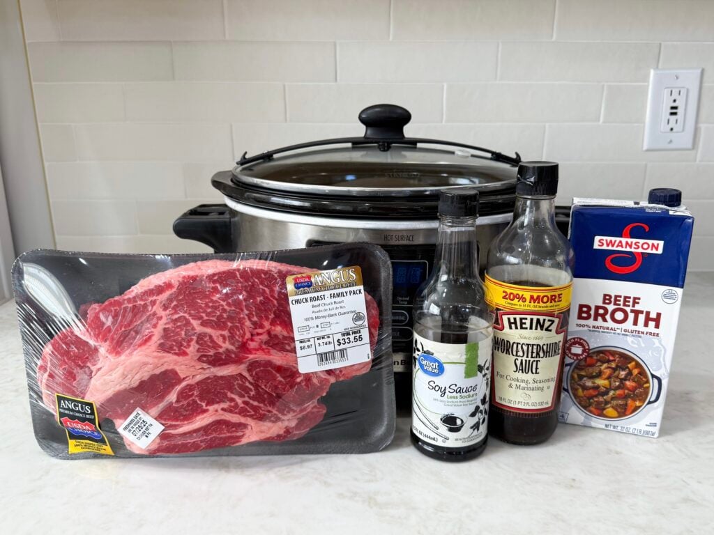 large slow cooker with raw beef roast with beef broth and soy sauce