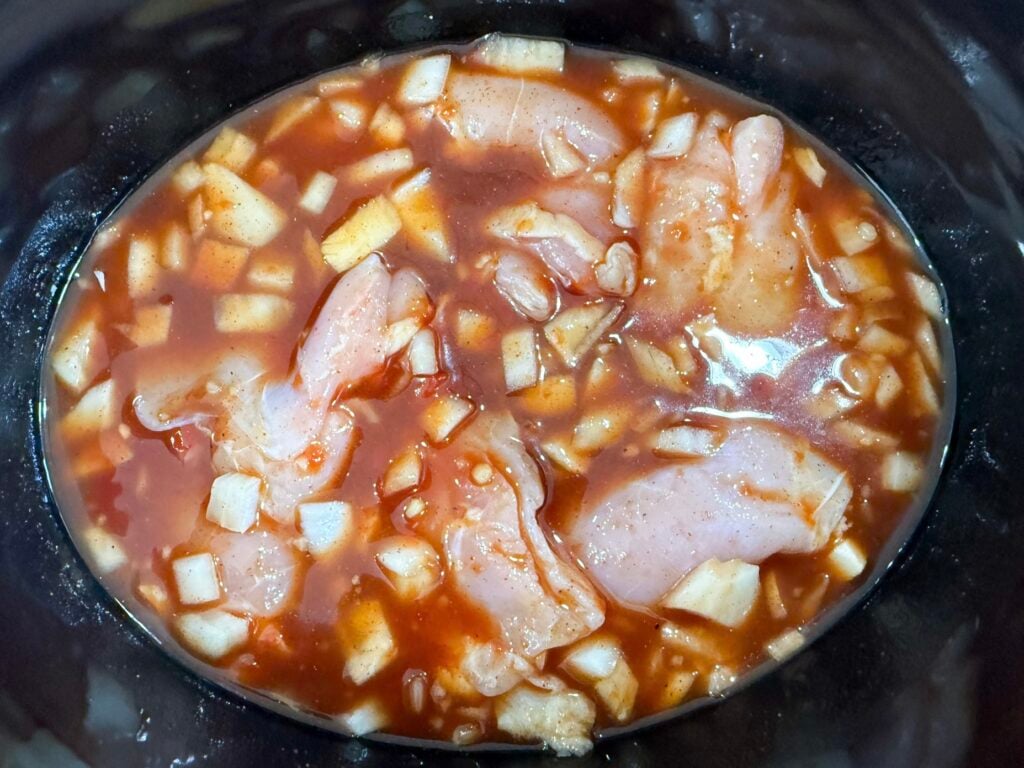 raw chicken in Hawaiian sauce in a slow cooker