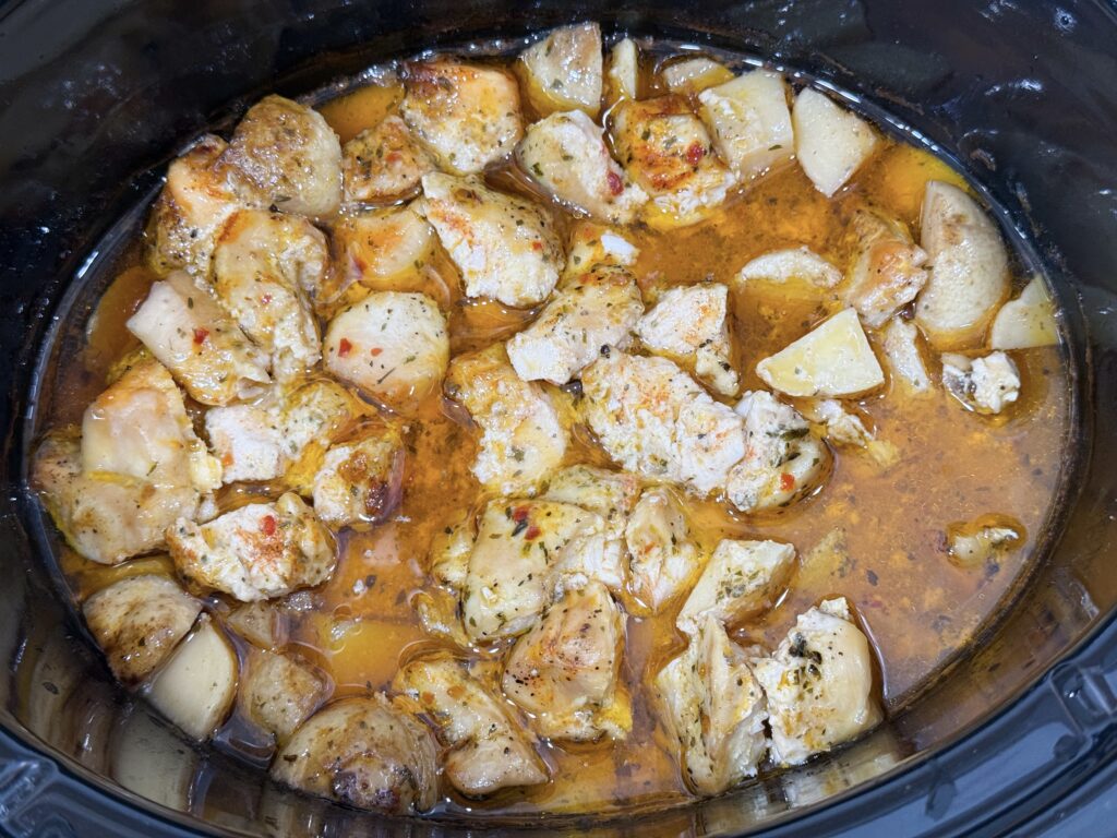 Cooked chicken in a garlic parmesan sauce in the slow cooker