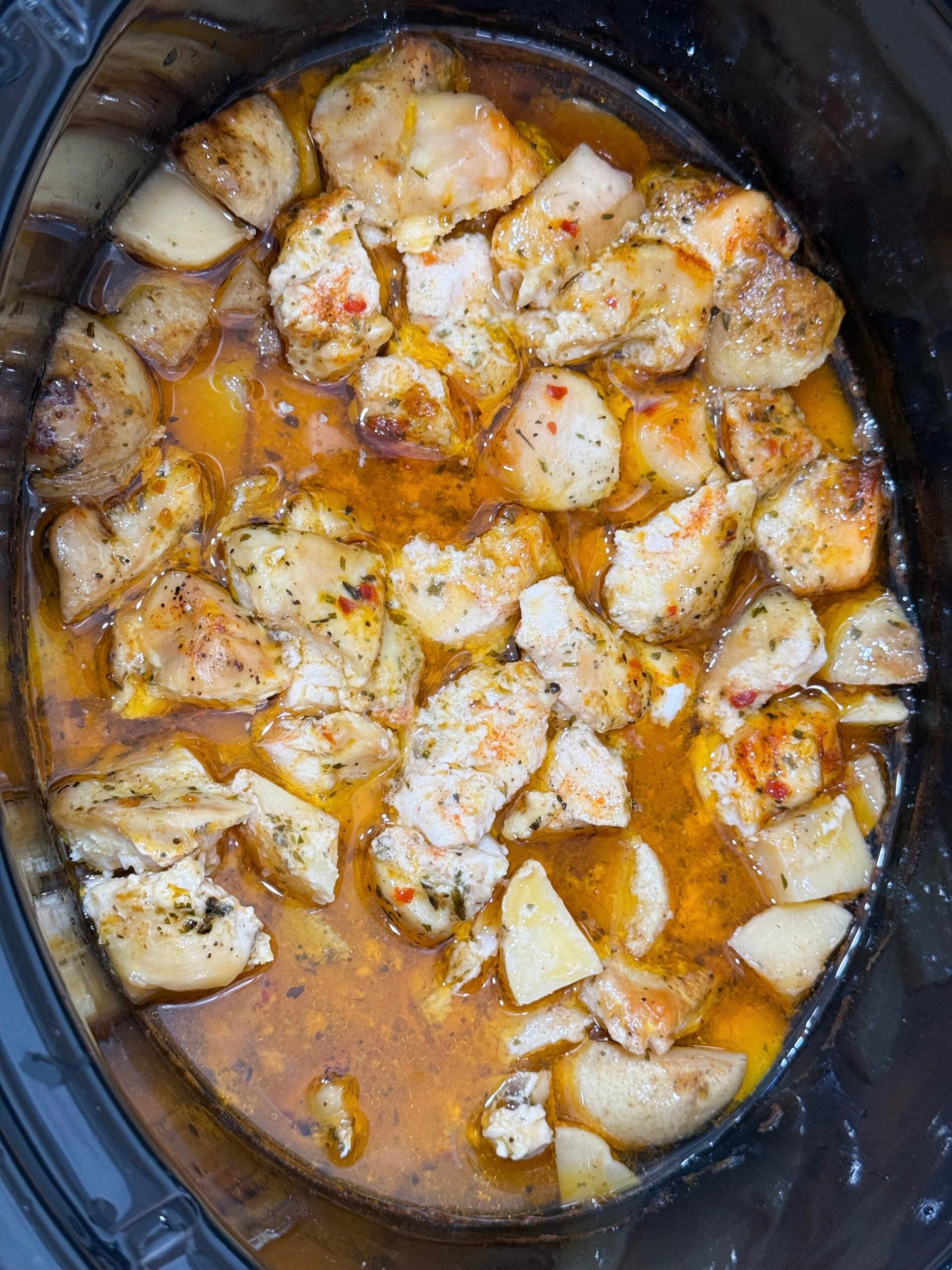 Cooked chicken in a garlic parmesan sauce in the slow cooker