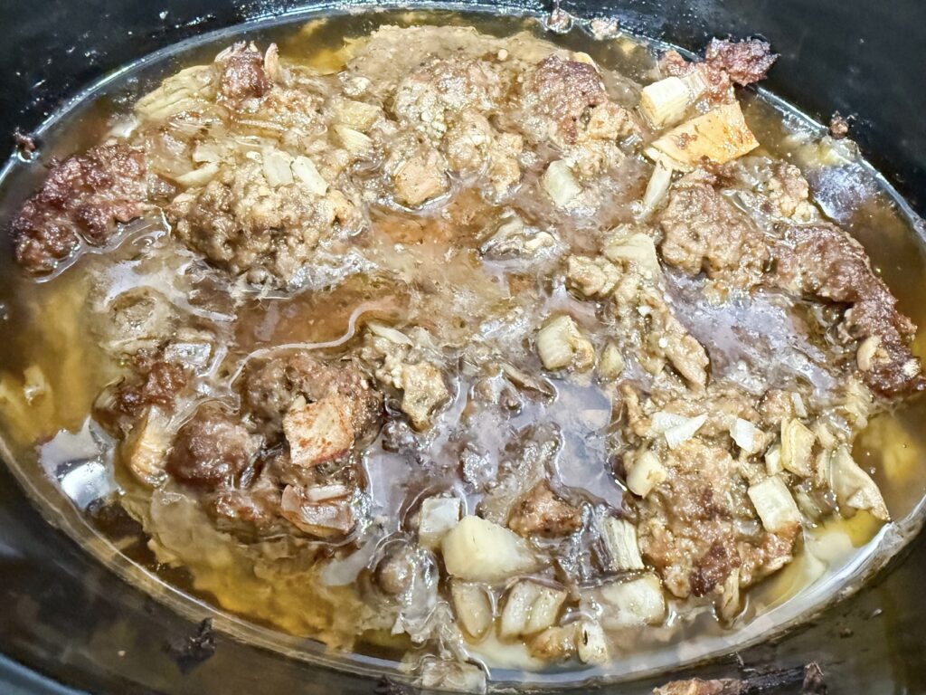 ground meat cooked in a black slow cooker