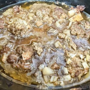 ground meat cooked in a black slow cooker