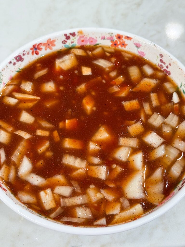 Onions in Hawaiian BBQ sauce in a white bowl with flowers