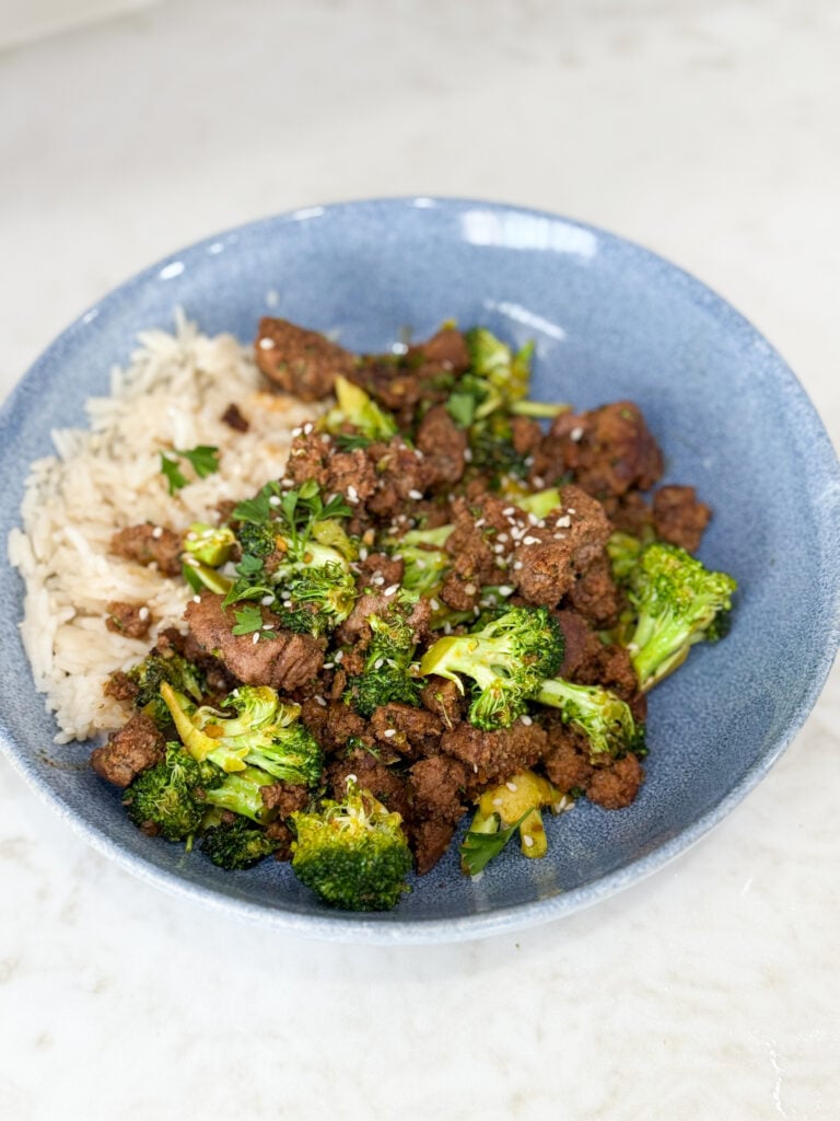 Cooked Sweet & Spicy Turkey and Broccoli Bowl Recipe in a blue bowl on a white counter