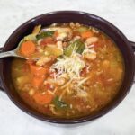 Bowl of Italian Vegetable and Sausage Soup topped with Parmesan