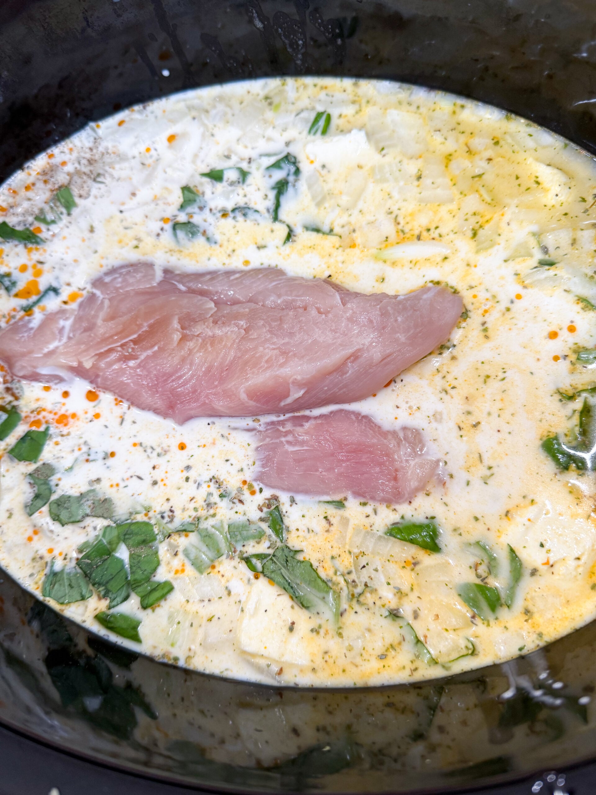 Chicken, cream cheese, and broth in slow cooker before cooking