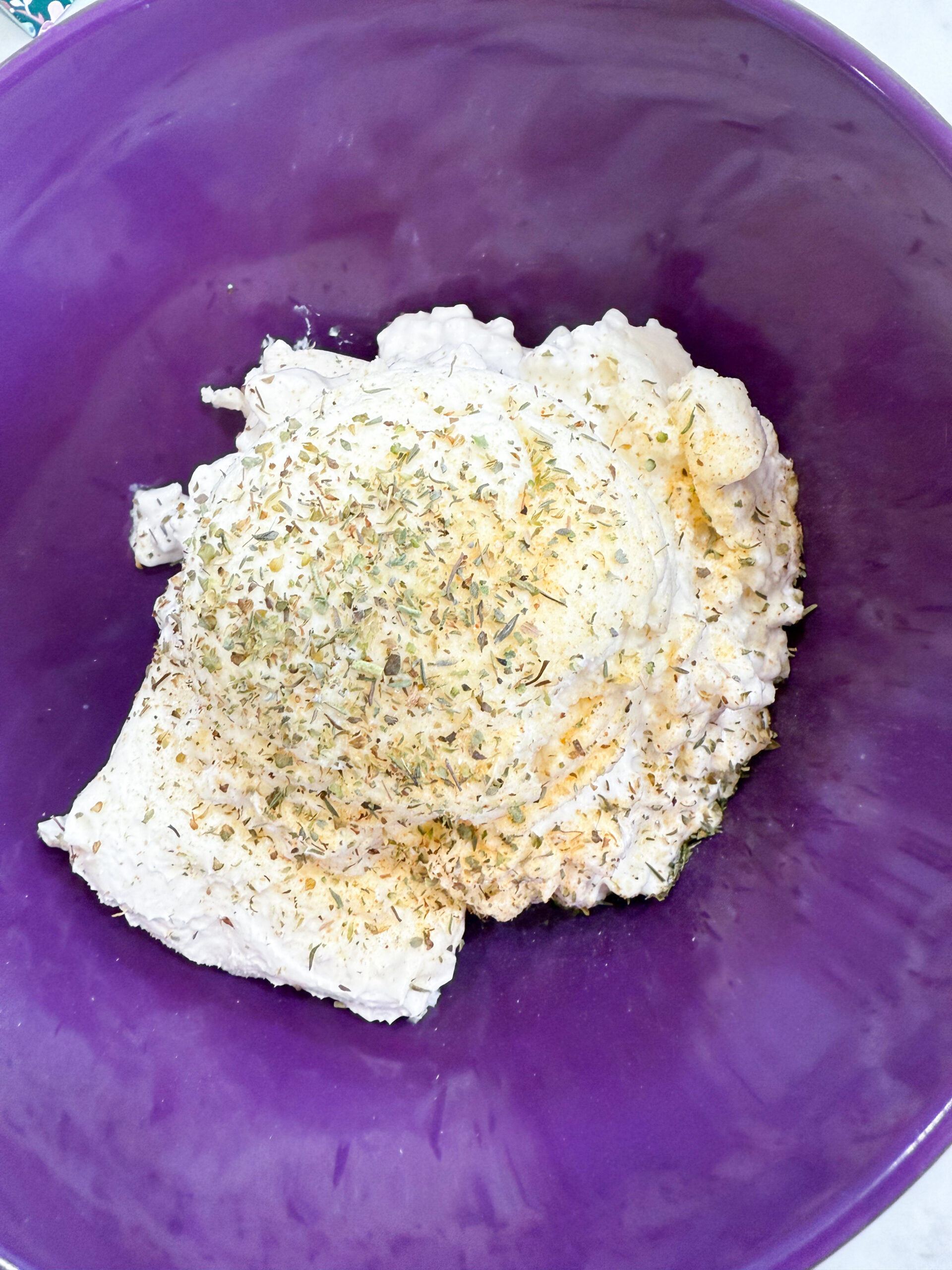 Ricotta, cream cheese, and seasonings blended together in a bowl for the creamy casserole filling.