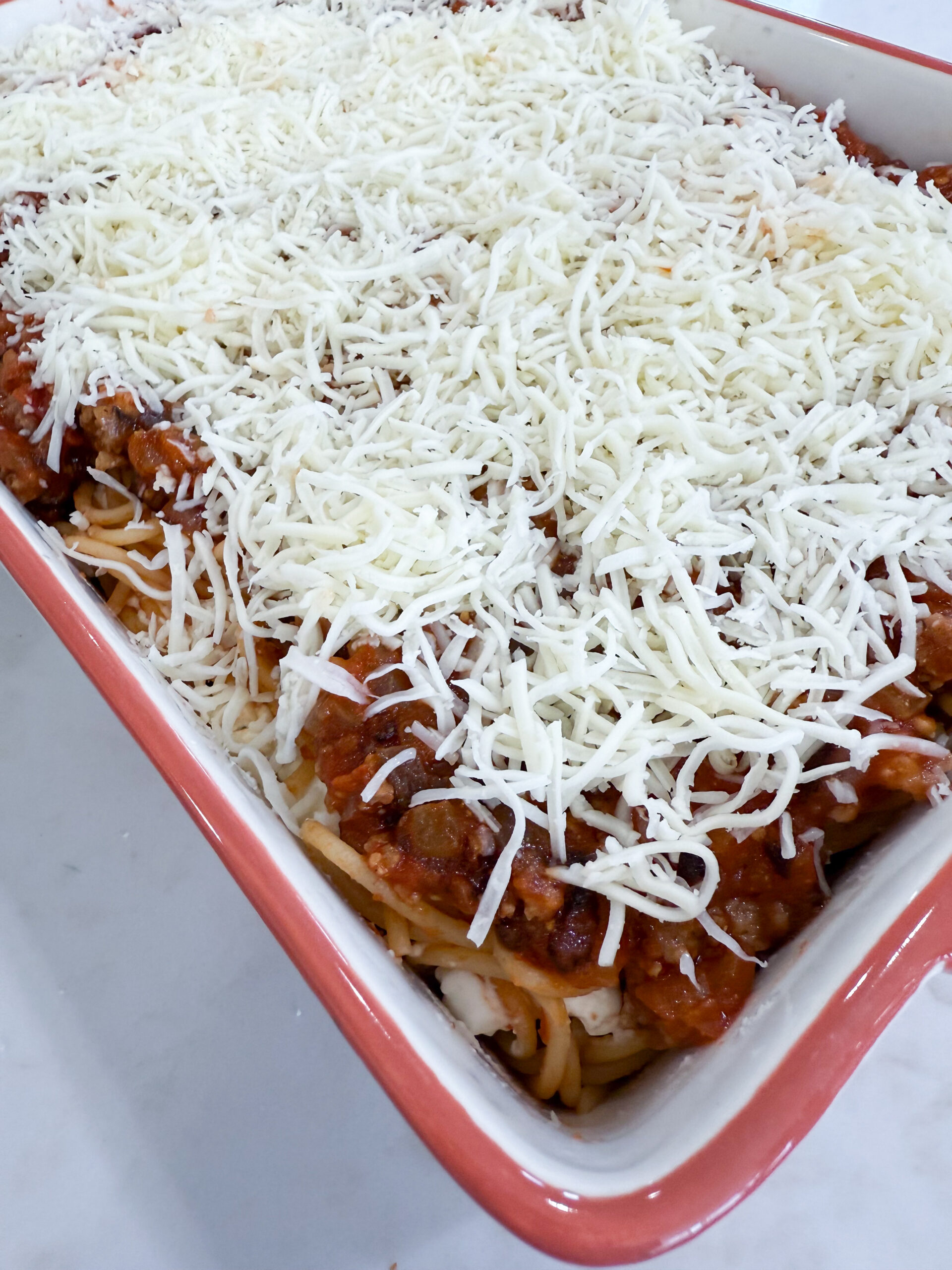 Shredded mozzarella sprinkled on top of the casserole before baking.