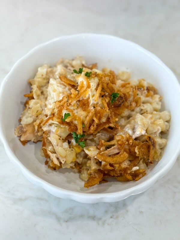 Serving of Onion Chicken Potato Casserole on a plate with chicken, potatoes, and crispy onion topping.