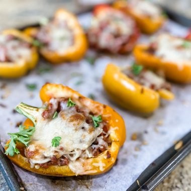 Stuffed bell peppers on a sheet pan with melted cheese on top