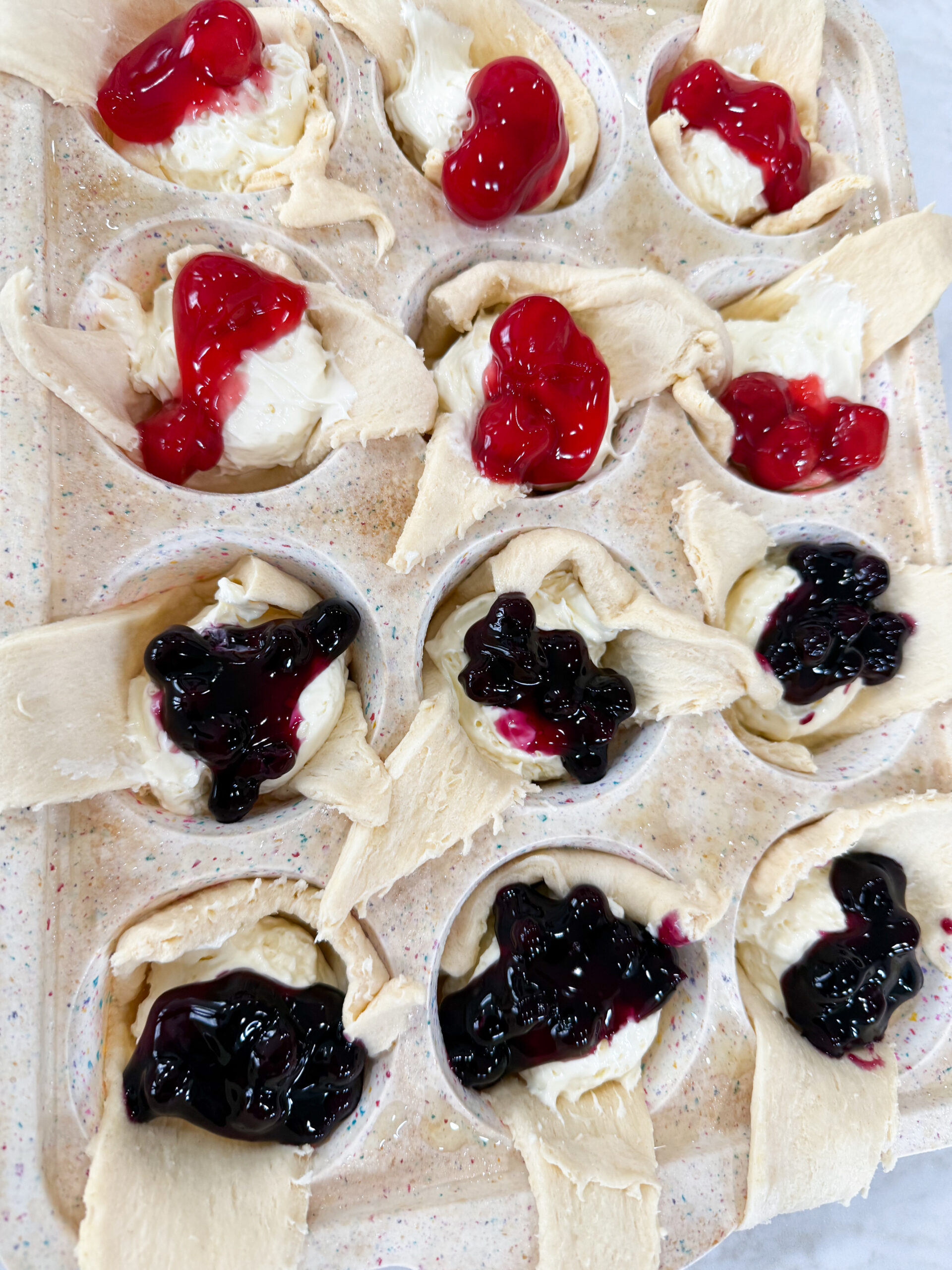 Golden mini cheesecake pies topped with blueberry and raspberry filling