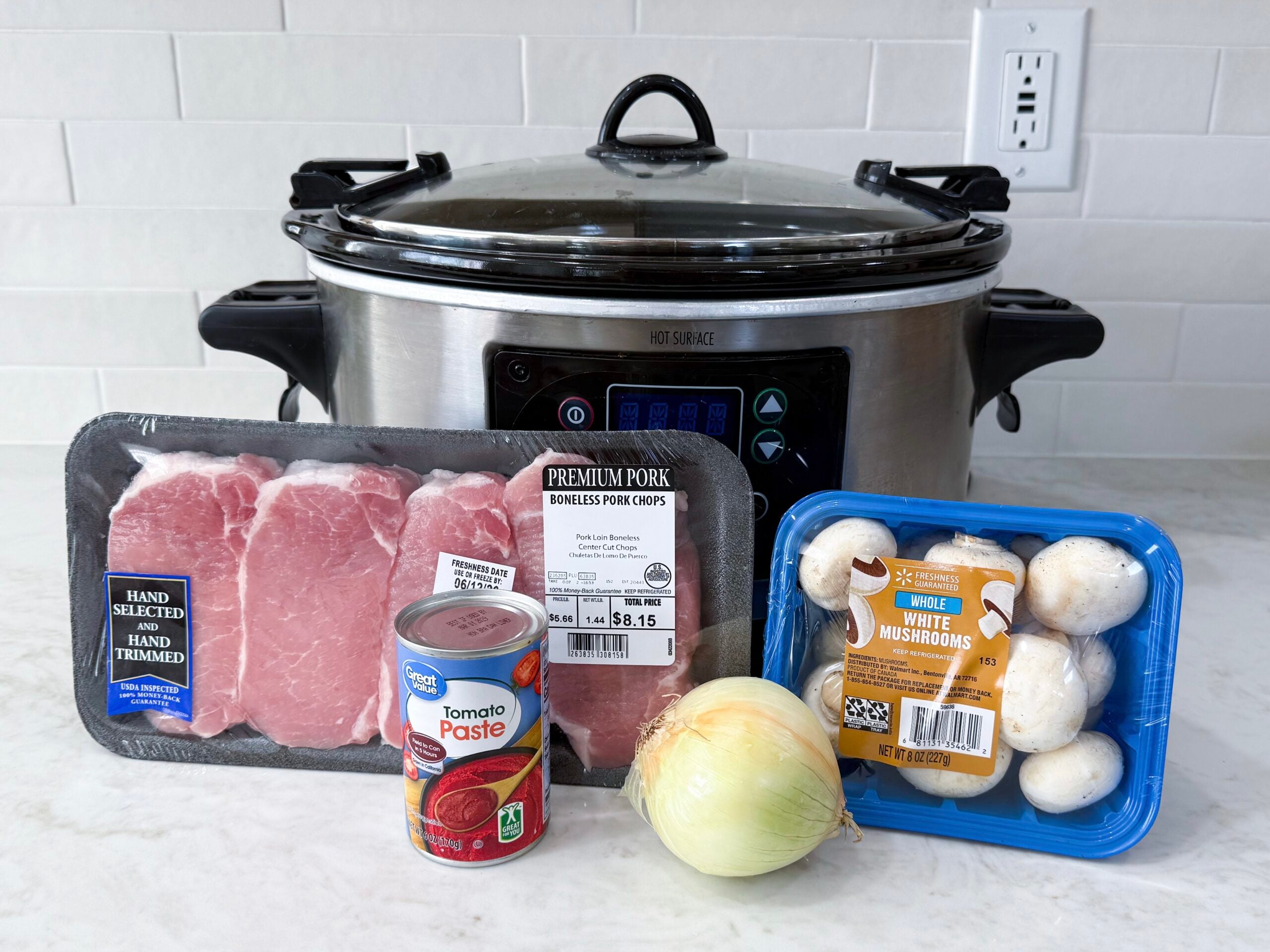 pork chops, yellow onion, mushrooms, and tomato paste on a counter