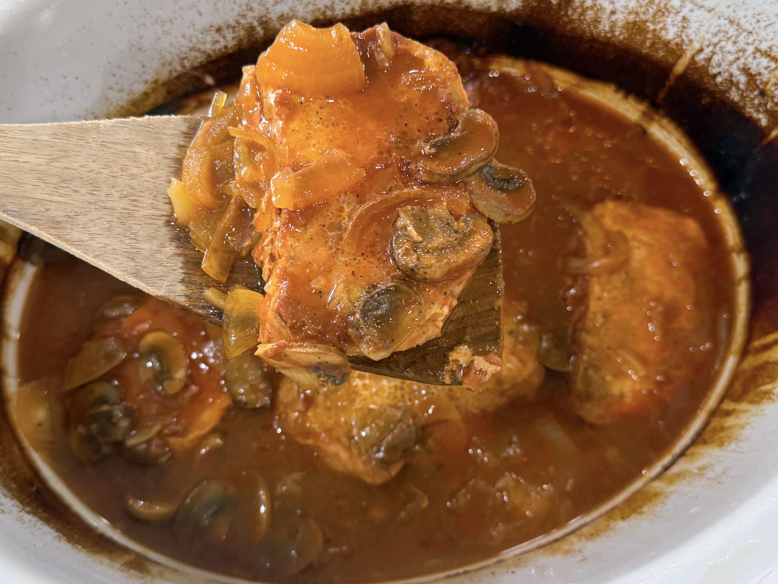 cooked pork chops covered with onion mushroom gravy in a slow cooker